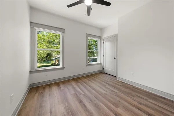 an empty room with a window and wooden floor
