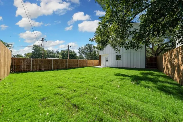 a view of a house with backyard and trees