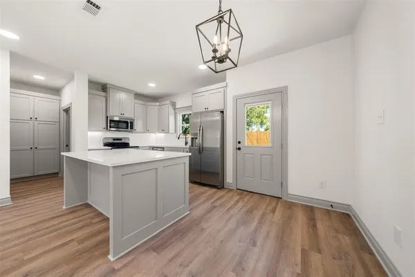 a kitchen with stainless steel appliances granite countertop a sink cabinets and wooden floor