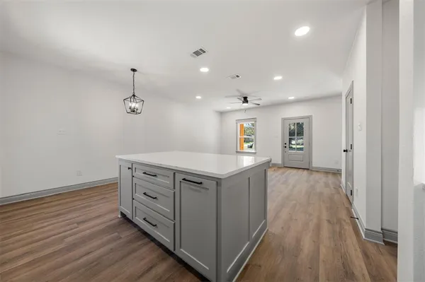 a kitchen with stove cabinets and wooden floor