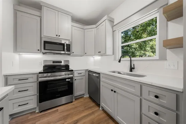 a view of a kitchen with a sink and wooden floor