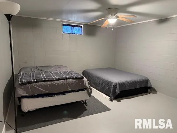 a bedroom with a bed and a lamp on the dresser