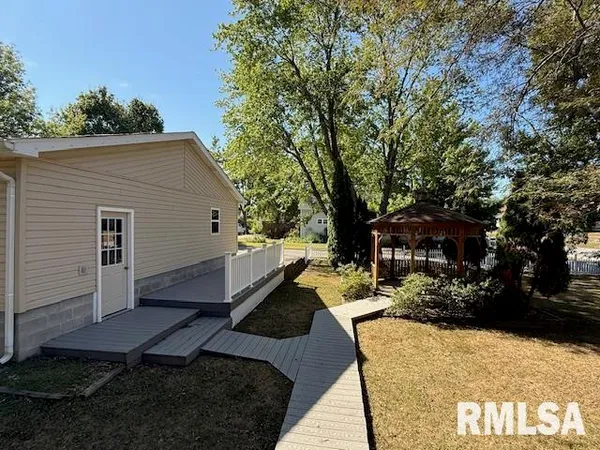 a view of a house with backyard and trees
