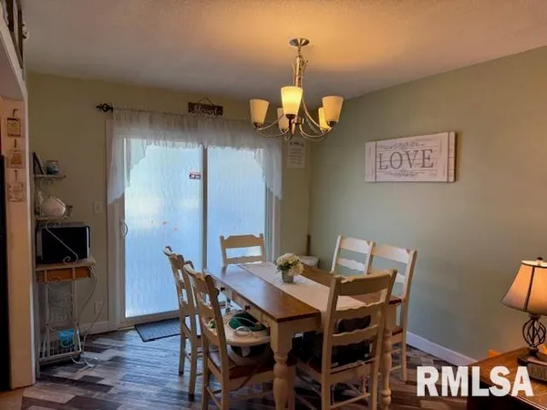 a view of a dining room with furniture wooden floor and chandelier