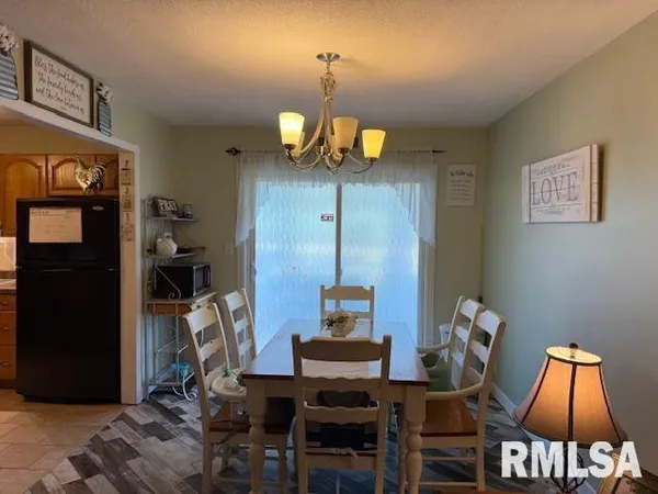 a dining room with wooden floor a chandelier a wooden table and chairs