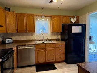 a kitchen with a sink dishwasher a stove and a refrigerator with wooden floor