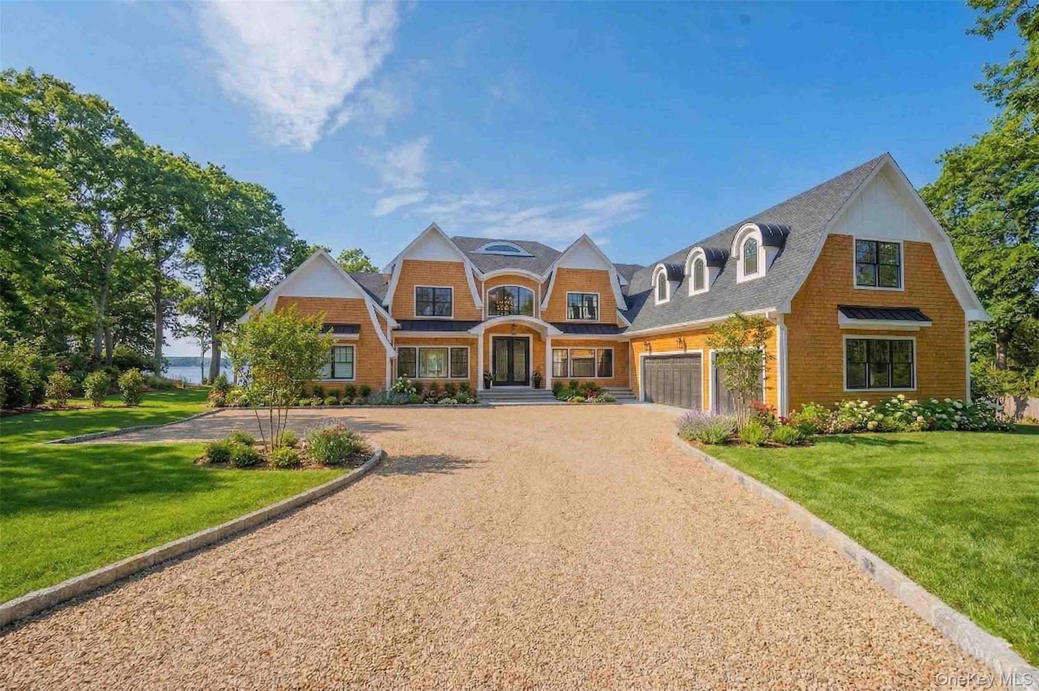 106 Cove Road Asharoken, NY 11768 - Photo 2 of 46 View of front of home featuring gravel driveway, a front yard, a garage, and brick siding