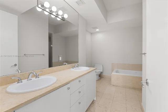 a bathroom with a tub shower and vanity
