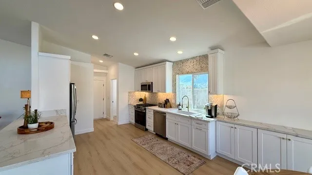 a kitchen with stainless steel appliances kitchen island granite countertop a sink and cabinets