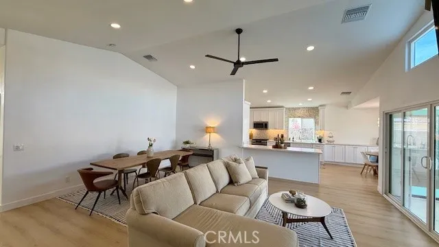 a living room with furniture and a dining table with wooden floor