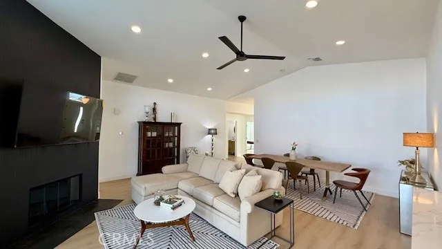 a living room with furniture a flat screen tv and a fireplace