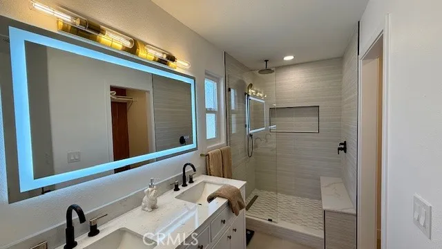 a bathroom with a shower sink and mirror