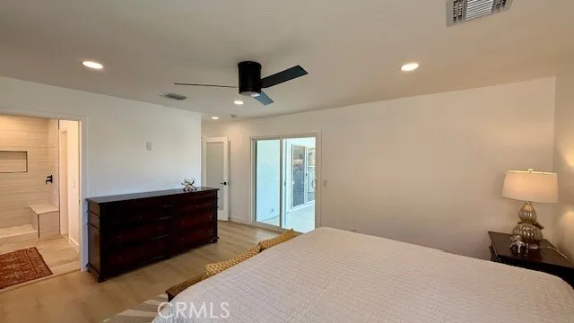 a bedroom with a bed and a lamp on a dresser