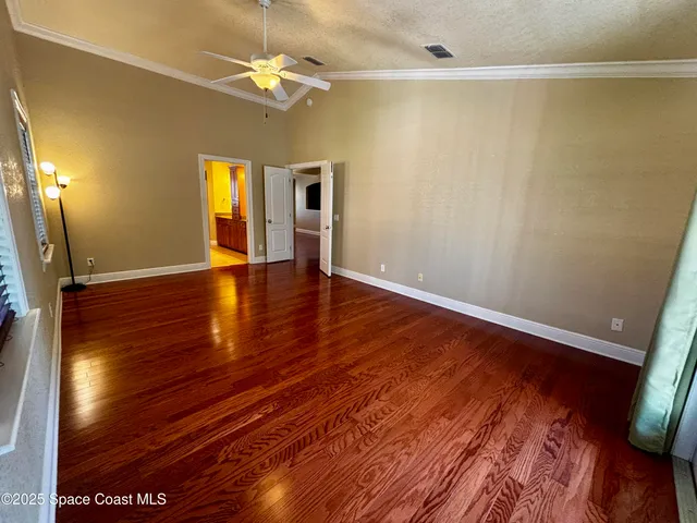 a view of empty room with wooden floor