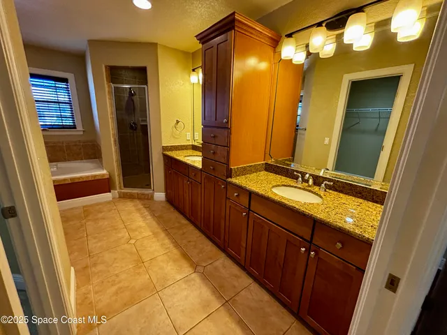 a bathroom with a granite countertop sink mirror and shower