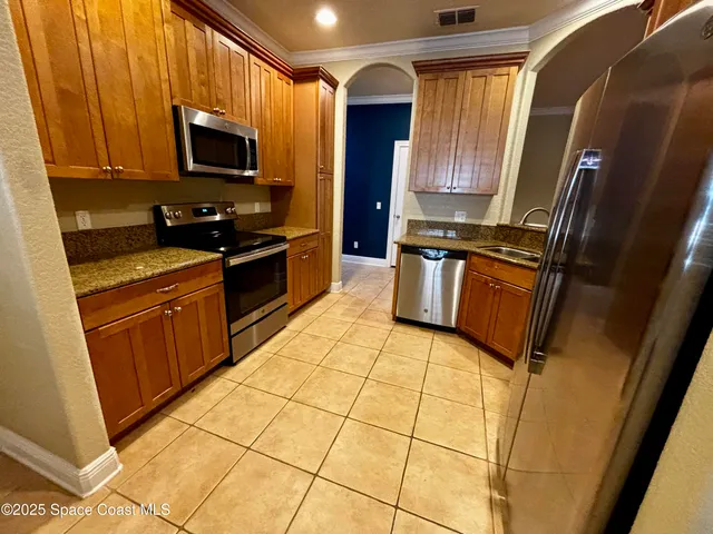 a kitchen with stainless steel appliances granite countertop a stove a sink and a microwave
