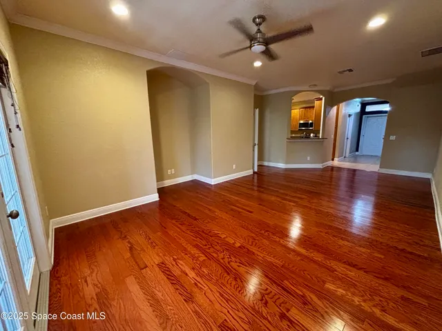 a view of empty room with wooden floor