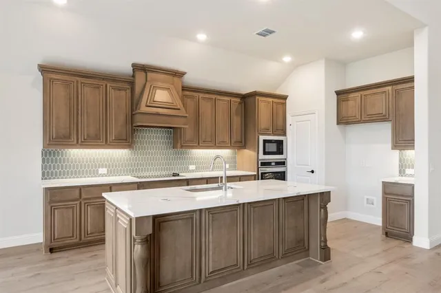 a kitchen with a sink cabinets and wooden floor