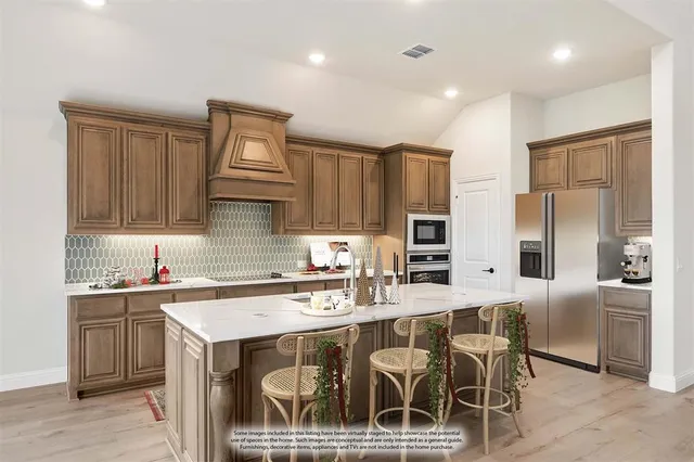 a kitchen with stainless steel appliances a sink stove and refrigerator