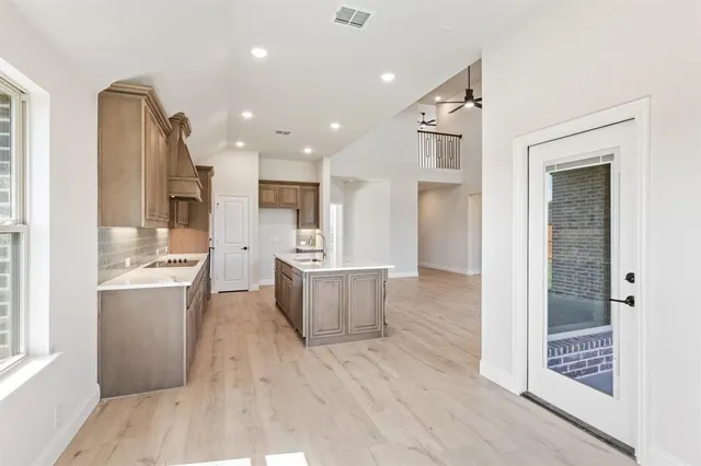 a open kitchen with kitchen island wooden cabinets and refrigerator