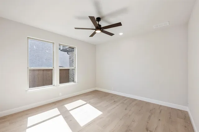 an empty room with a window and a ceiling fan