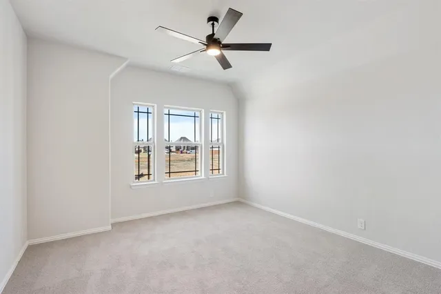 an empty room with a window and a fan