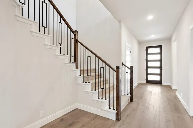 a view of a hallway with wooden floor and entryway