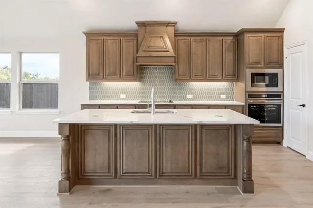 a kitchen with kitchen island granite countertop a stove and a sink