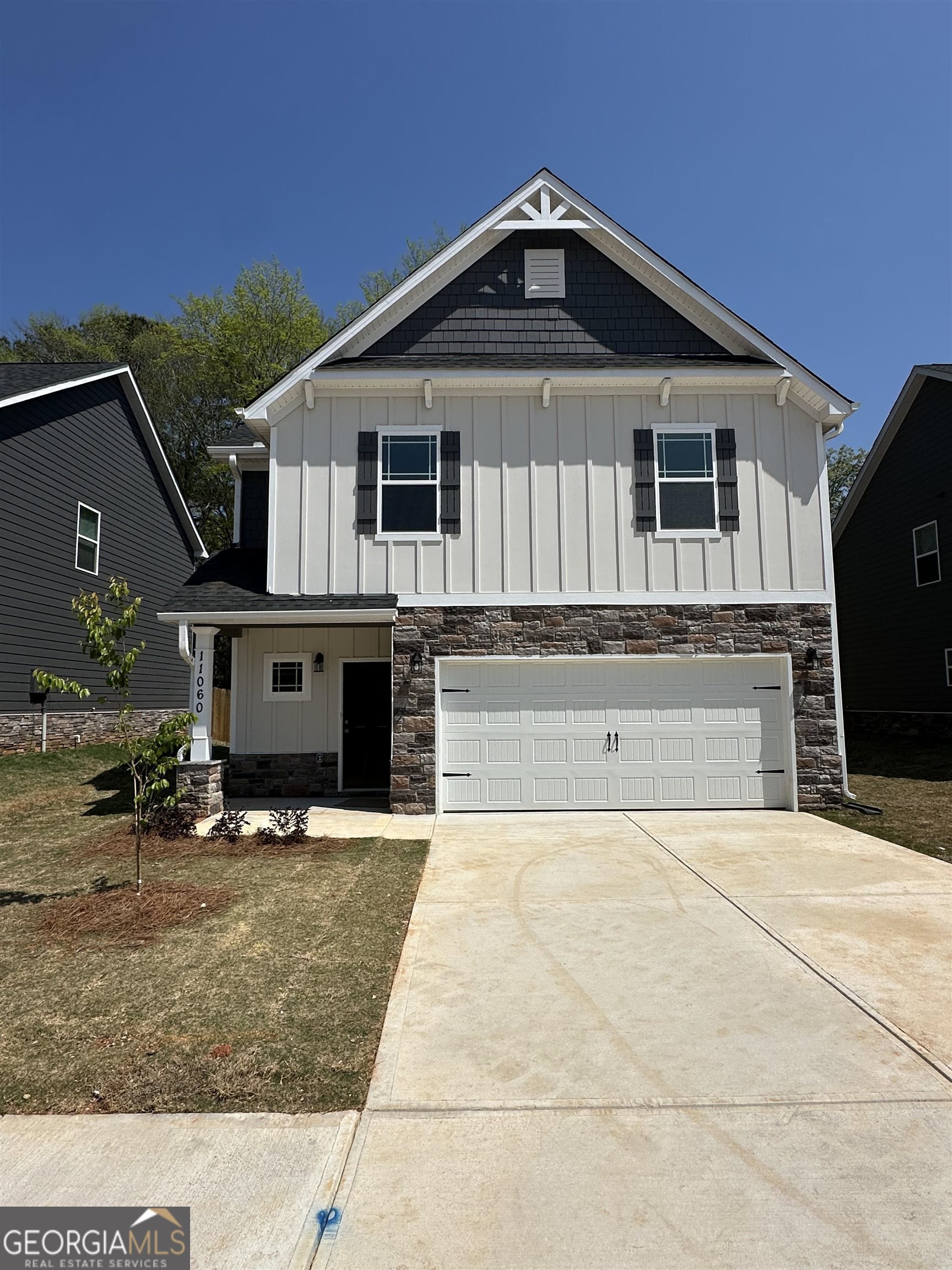 a front view of a house with yard and parking space