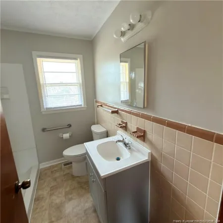 a bathroom with a sink a toilet and mirror