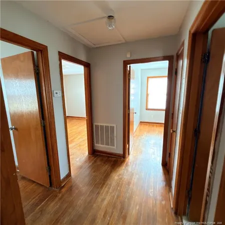 a view of a hallway with wooden floor and stairs