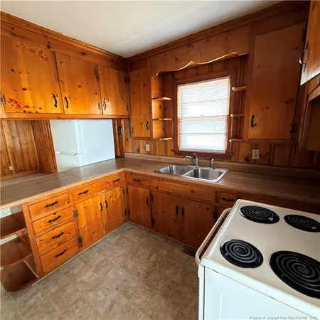 a kitchen with stainless steel appliances granite countertop a sink a stove and a refrigerator