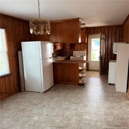 a kitchen with stainless steel appliances granite countertop a refrigerator a sink dishwasher a stove and a dining table with wooden floor