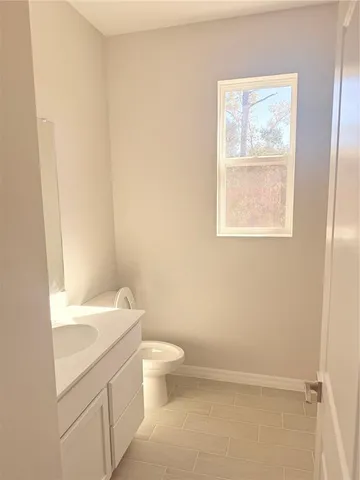 a view of empty room with kitchen and window