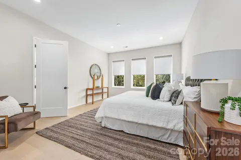 a bedroom with a large bed and wooden floor
