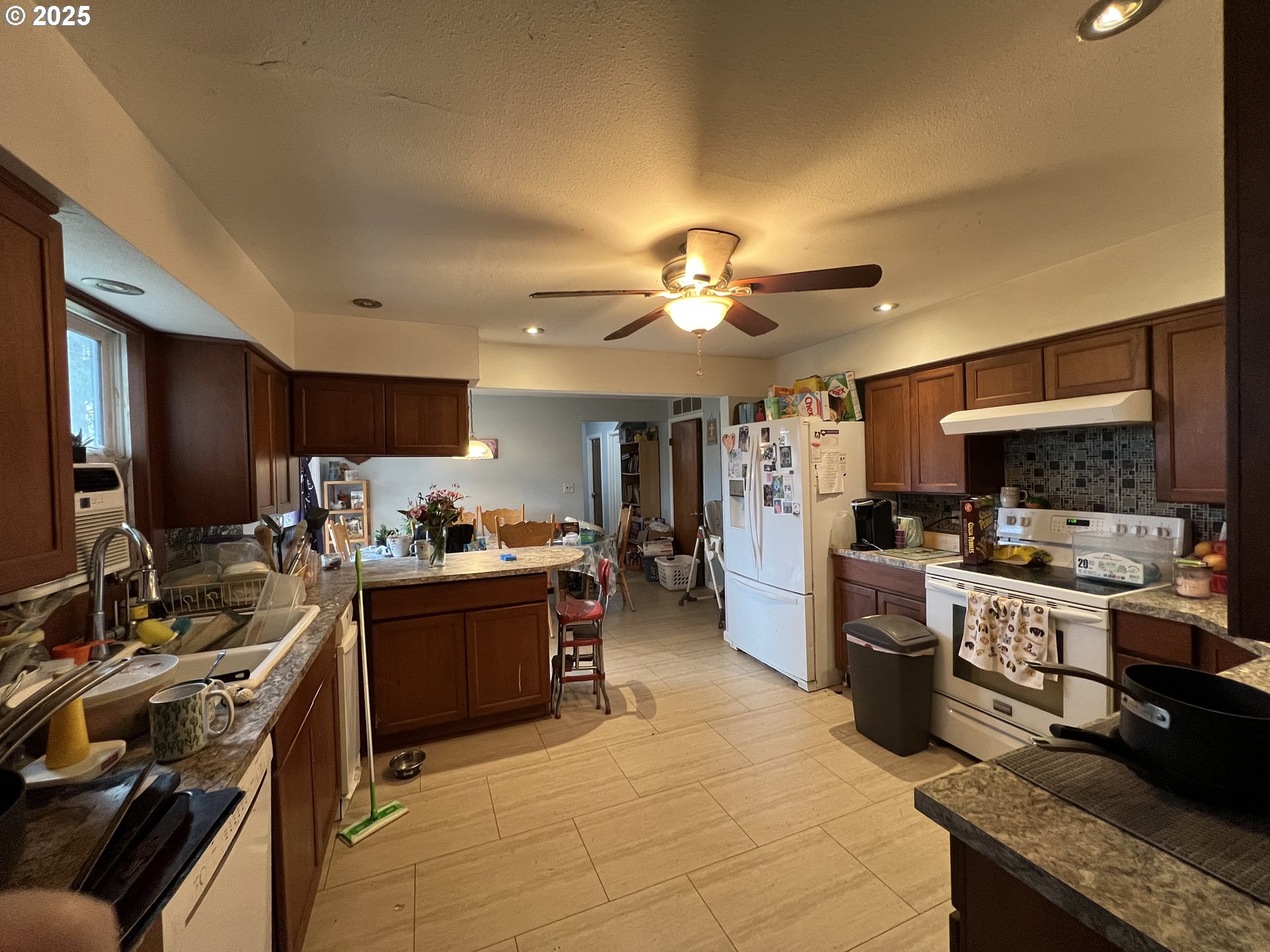 933 Southeast 174th Avenue Portland, OR 97233 - Photo 2 of 14 a kitchen with kitchen island granite countertop lots of counter top space a sink stainless steel appliances and cabinets