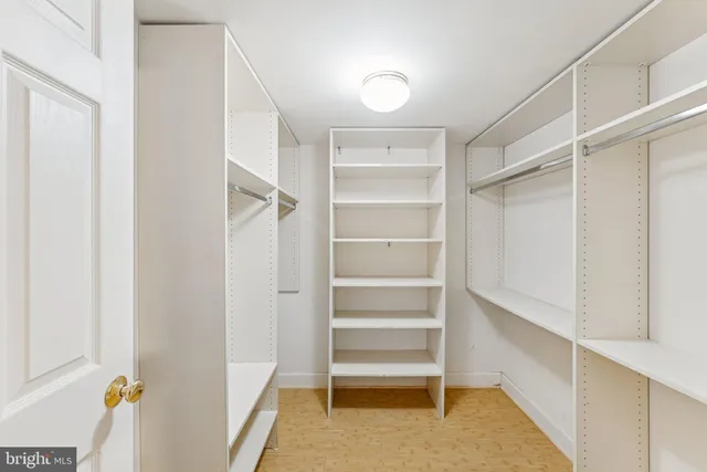 a view of walk in closet with empty racks