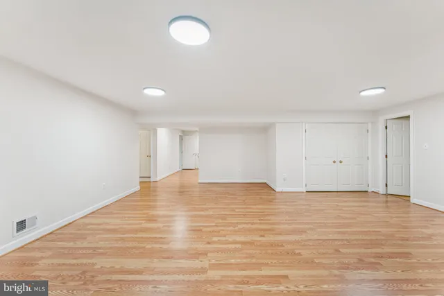 a view of an empty room with wooden floor