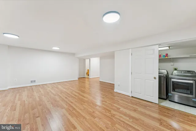 a view of empty room with wooden floor and electronic appliances