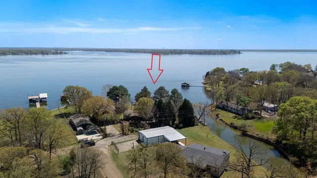 an aerial view of a house with a yard and lake view