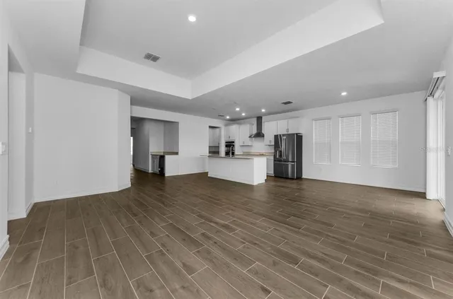 a view of empty room with wooden floor