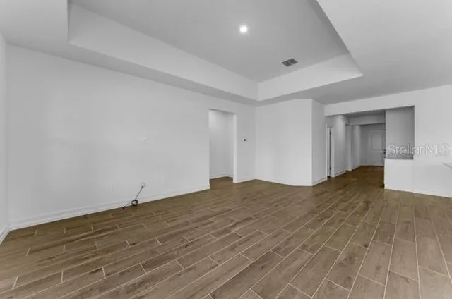 a view of empty room with wooden floor