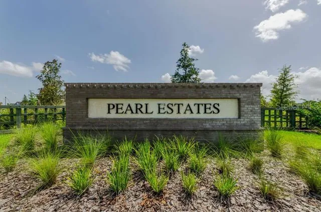 a sign of golf club on a wall under a tree