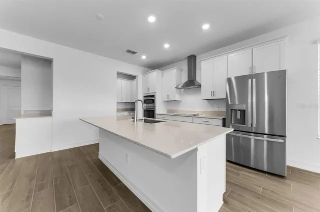 a kitchen with stainless steel appliances a refrigerator sink and microwave