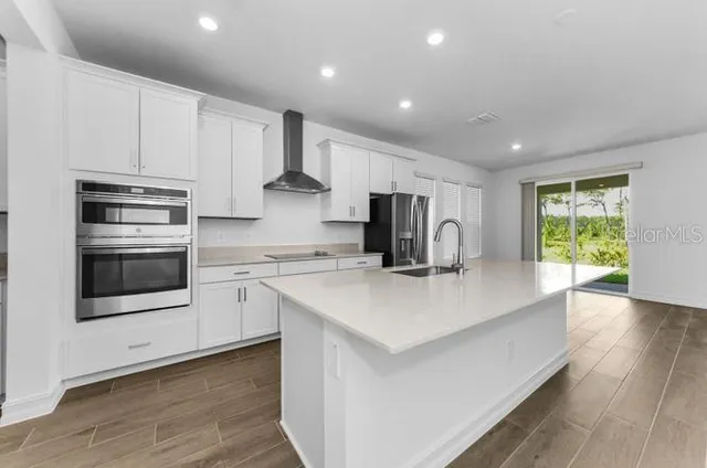 a kitchen with stainless steel appliances a stove a sink a refrigerator and cabinets