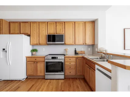 a kitchen with a refrigerator a stove top oven a sink and dishwasher