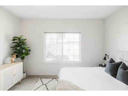 a bedroom with a bed lamp and a window