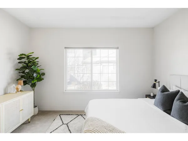 a bedroom with a bed lamp and a window