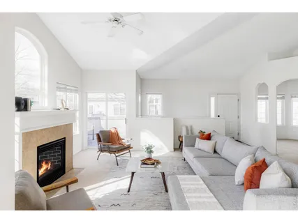 a living room with furniture a fireplace and a floor to ceiling window