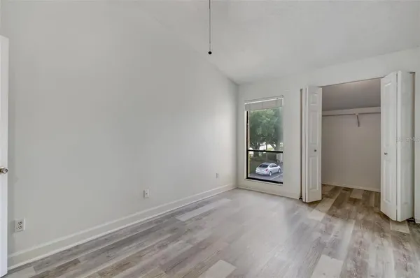 a view of a big room with wooden floor and windows